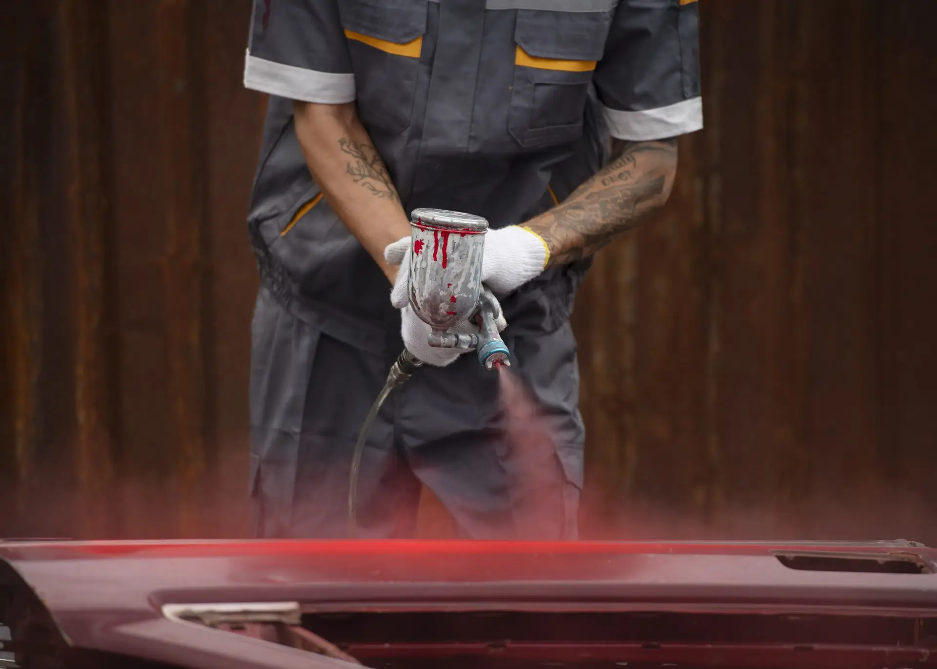 front view worker spraying powder paint from gum