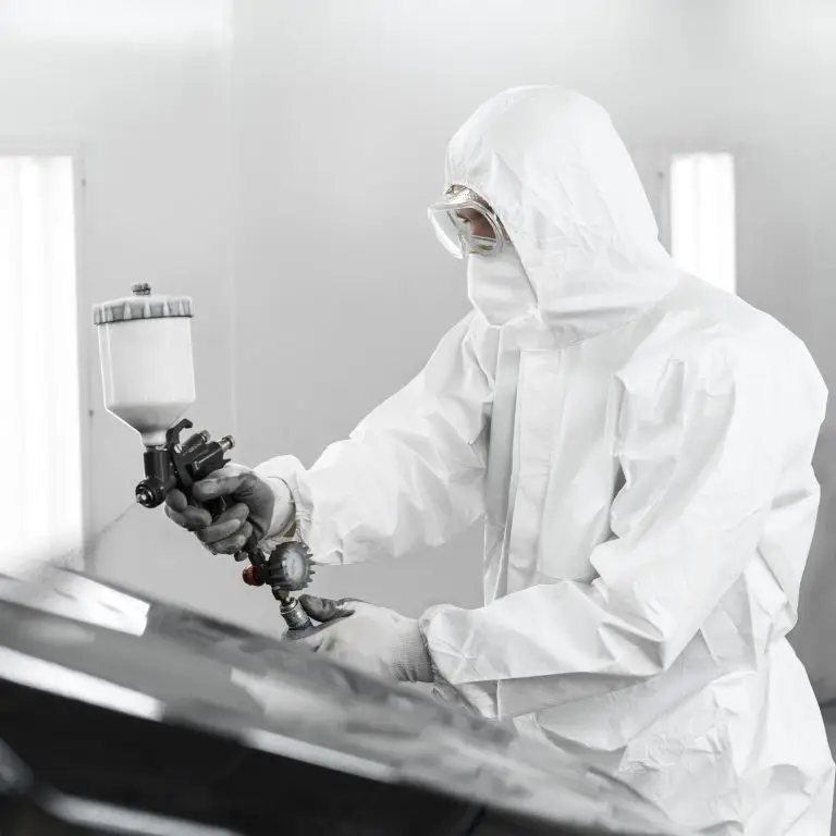 man hazmat suit using gun paint car shop