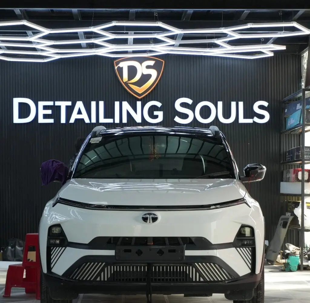 White Tata vehicle undergoing final inspection after top PPF installation under studio lights at Detailing Souls